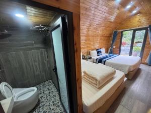 a room with two beds and a bathroom with a shower at Plum Hillside Lodge in Dồng Văn +101 photos
