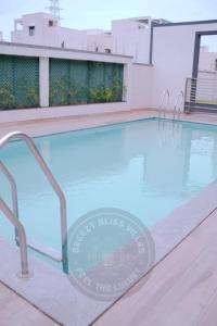 a swimming pool with a sign on the side of a building at Breezy Classy Villa Mahabalipuram in Kelambākkam