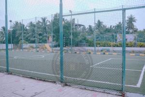 a tennis court with a net on a tennis court at Breezy Classy Villa Mahabalipuram in Kelambākkam