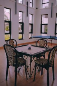 a table and chairs in a room with windows at Breezy Classy Villa Mahabalipuram in Kelambākkam