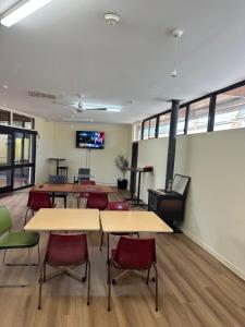 a classroom with tables and chairs and a wood stove at Workforce Accommodation in Kalgoorlie