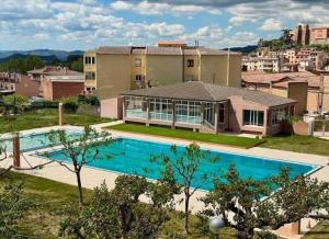 a large house with a swimming pool in front of it at Hotel-Hostal Sport in Falset