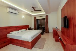 a bedroom with a bed and a flat screen tv at Sunlit Shores Beach Villa in Kundapur