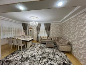 ein Wohnzimmer mit einem Tisch und ein Esszimmer in der Unterkunft Zirvə in Quba