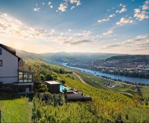 a house on a hill next to a river at Villa Orange Tree in Bernkastel-Kues