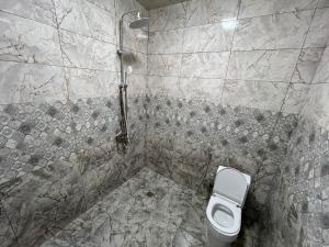 ein gefliestes Badezimmer mit Toilette und Dusche in der Unterkunft Zirvə in Quba