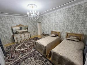 ein Schlafzimmer mit zwei Betten, einem Spiegel und einem Kronleuchter in der Unterkunft Zirvə in Quba