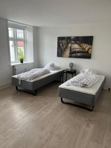 a bedroom with two beds and a painting on the wall at Niollo Hotels in Aabenraa +40 photos