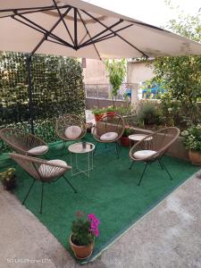 a patio with chairs and tables and an umbrella at Apartman Nika in Drniš
