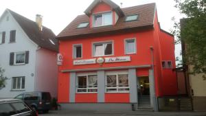 un edificio rojo y blanco con una tienda en Fino da Mario, en Ebersbach an der Fils