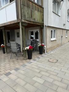 a patio with two chairs and flowers in front of a building at Charmigt in Gränna