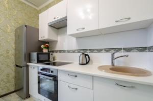a kitchen with white cabinets and a sink and a microwave at Панорамний Краєвид на Озеро Позняки Жк Лебединий in Kyiv