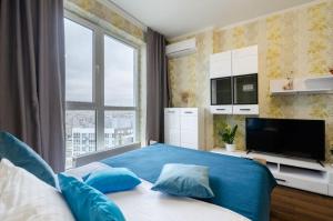 a bedroom with a blue bed and a large window at Панорамний Краєвид на Озеро Позняки Жк Лебединий in Kyiv