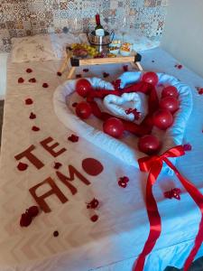 a bed with a heart made out of red balloons at Sítio com suítes e áreas de Lazer in Palmeiras