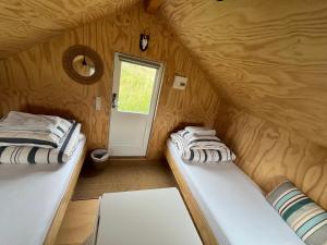 two beds in a small room with a door at Skansely in Sønderborg