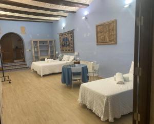 a room with two beds and a table in it at Garden Suites Xativa Casa Rural in Xàtiva