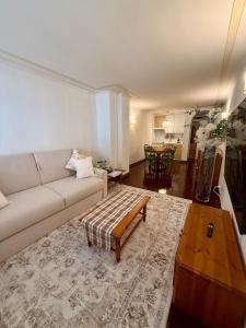 a living room with a couch and a coffee table at Maison Moena Dolomites in Moena