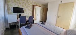 a bedroom with two beds and a table and a television at Ferienunterkunft Bella Italia in Friedrichshafen +11 photos