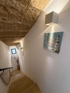 a stairway with a picture of a lighthouse on the wall at Sea Salt in Terrasini