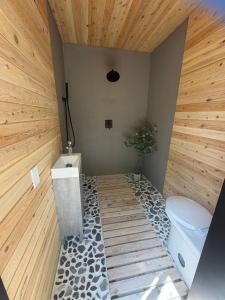 a bathroom with a toilet and a wooden wall at Mytik Shack Sucré in Saint-René-de-Matane