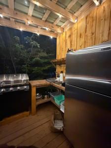 a kitchen with a stove and a refrigerator at Mytik Shack Sucré in Saint-René-de-Matane
