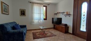 a living room with a couch and a tv at RAMERAHouse in Mareno di Piave