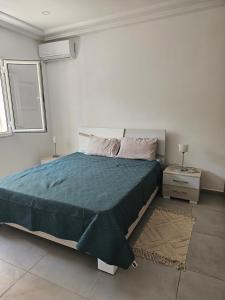 a bedroom with a large bed with a blue blanket at Villa Wissal Djerba piscine privée in Arkou
