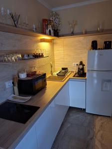 a kitchen with a white refrigerator and a sink at Szabó Vendégház in Bükkszék
