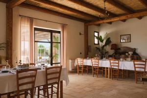 a dining room with white tables and chairs at Masseria Voluzzi in Copertino