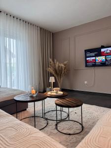 a living room with two tables and a tv at Exclusive Una 4 in Bihać