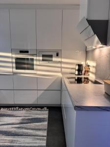 a white kitchen with white cabinets and a stove at Exclusive Una 4 in Bihać