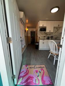 a hallway with a welcome mat on the floor of a kitchen at The conch cottage in Crystal River