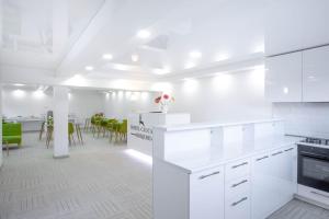 a white kitchen with white appliances and a dining room at Hotel Caucasus Borjomi in Borjomi +12 photos