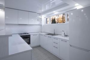 a white kitchen with white cabinets and a sink at Hotel Caucasus Borjomi in Borjomi