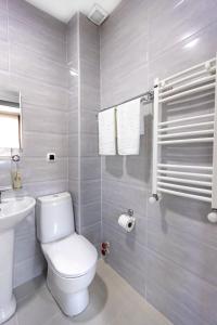 a white bathroom with a toilet and a sink at Hotel Caucasus Borjomi in Borjomi