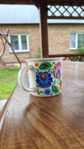 a coffee cup sitting on top of a wooden table at Agroturystyka Kryjówka Nad Stawem in Kodeń