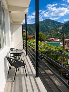 a balcony with a table and chairs and a view at Hotel Caucasus Borjomi in Borjomi