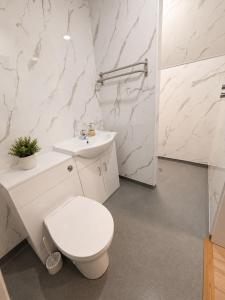 a white bathroom with a toilet and a sink at 7 Bed, 7 BR Victorian Accom - Sleeps 14 in Walsall +24 photos