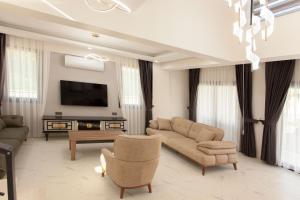 a living room with a couch and a tv at Cesur Villa in Fethiye