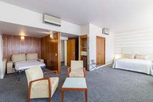 a hotel room with two beds and a table and chairs at Hotel Eurosol Leiria & Jardim in Leiria