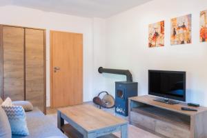 a living room with a tv and a table at Chata Rozhlas in Železná Ruda