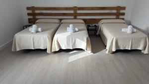 two beds in a room with wooden floors at VTAR Casa Carmen en Gilena in Gilena +2 photos