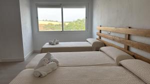 a room with three beds with a window at VTAR Casa Carmen en Gilena in Gilena