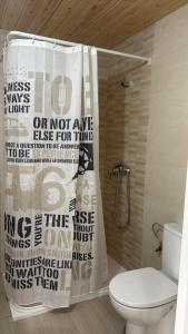 a bathroom with a toilet and a shower curtain at VTAR Casa Carmen en Gilena in Gilena