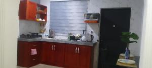 a kitchen with wooden cabinets and a sink and a window at MVH Apartment - Chamber and hall unit in Sunyani