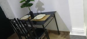 a black table with two chairs and a plant on it at MVH Apartment - Chamber and hall unit in Sunyani