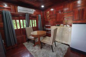 a kitchen with a table and chairs in a room at แพในฝัน รีสอร์ท in Ban Tha Thong Mon