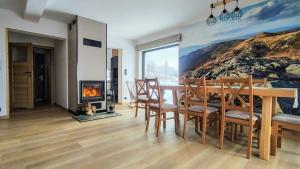 a dining room with a table and a fireplace at Widokówka in Baligród
