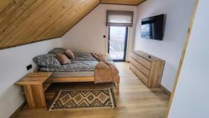 a bedroom with a bed and a tv in a room at Widokówka in Baligród