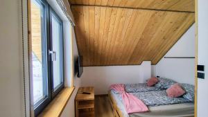 a bedroom with a bed and a wooden ceiling at Widokówka in Baligród